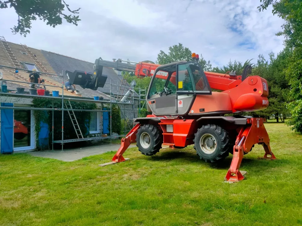 Machine élévatrice sur chantier avec échafaudage, vue extérieure d’un bâtiment.