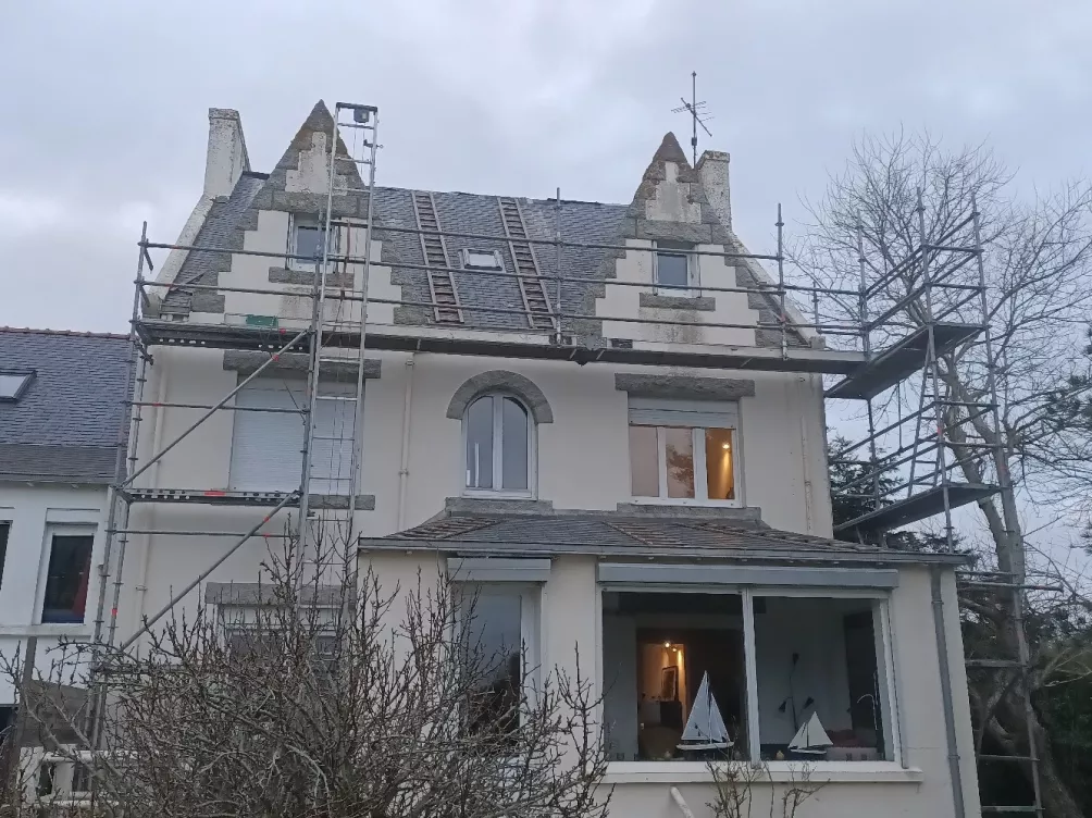 Toiture avec échafaudage en construction, fenêtres de toit visibles.